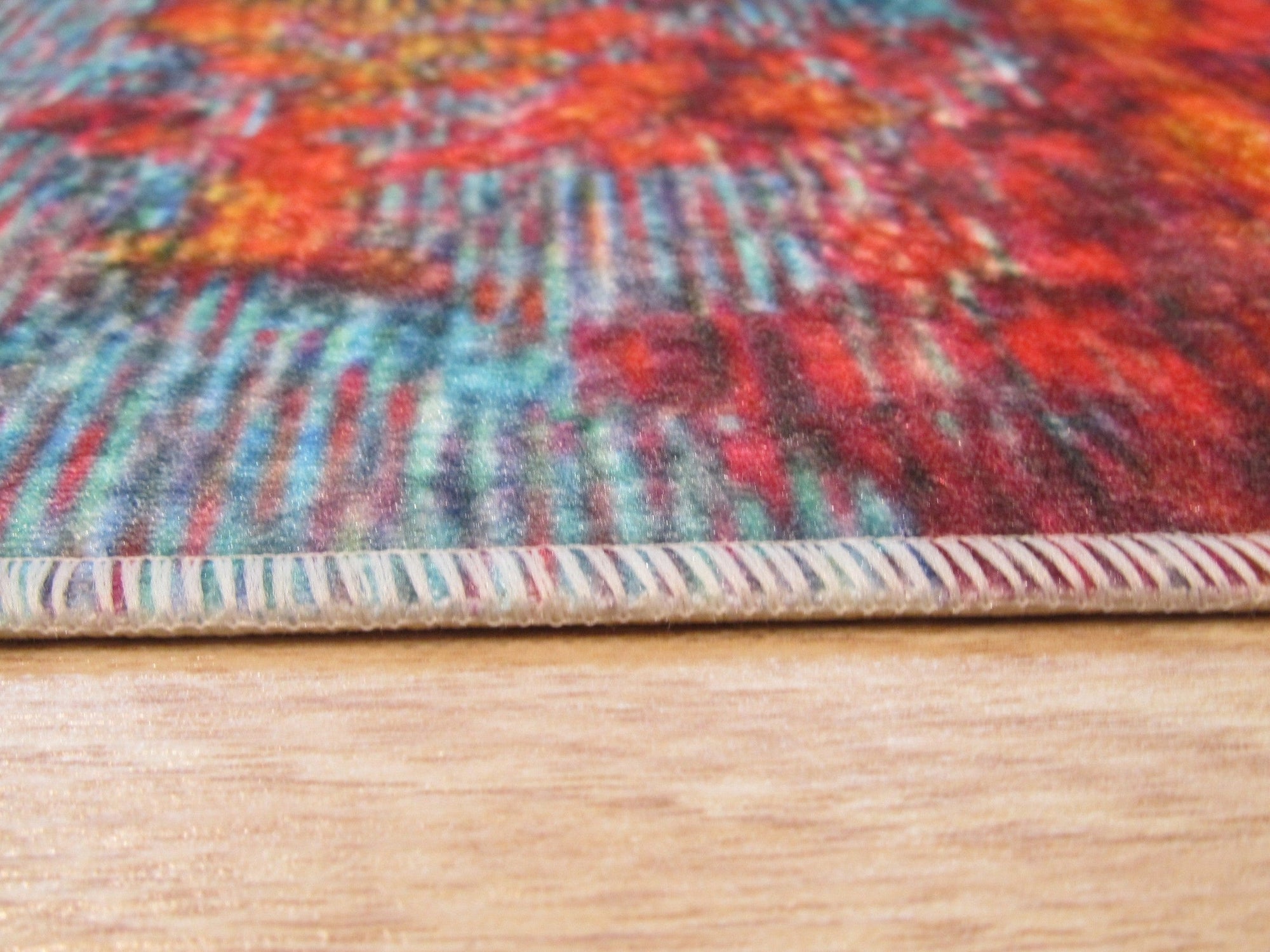 Bianca Isla Red Machine Made Rug, displays a vibrant geometric pattern in shades of red, cream, and brown, creating a warm and inviting atmosphere on hardwood floors.