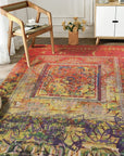 Xena Artistic Multicolor Machine Made Rug, vibrant blend of blues, oranges, greens, and purples creates an abstract art piece underfoot in a modern living room setting.
