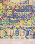 Xena Artistic Multicolor Machine Made Rug displayed in a bright, modern living room; vibrant splashes of blues, oranges, and yellows create an abstract pattern across the machine-made fibers, anchoring the seating area.