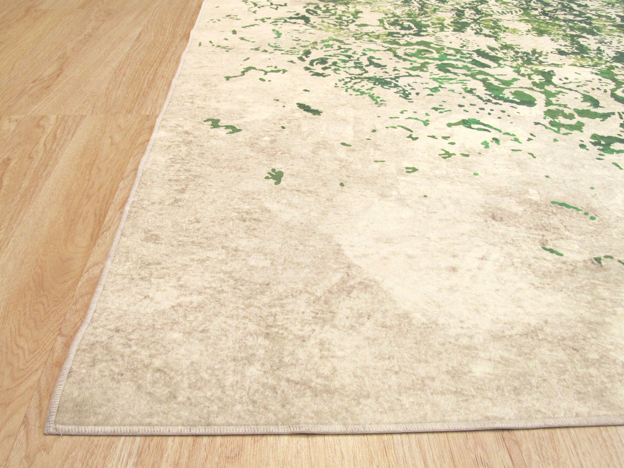 Sophie Jasmine Green Machine Made Rug displayed on a hardwood floor, its intricate floral design and lush green hues creating a serene and inviting atmosphere.