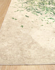 Sophie Jasmine Green Machine Made Rug displayed on a hardwood floor, its intricate floral design and lush green hues creating a serene and inviting atmosphere.