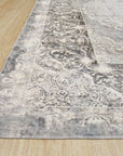 Bianca Warm Gray Machine Made Rug displayed in a bright, modern living room. Soft, warm gray tones and subtle geometric pattern complement neutral furniture, creating a cozy and inviting atmosphere. Machine-made construction offers durability and easy care.