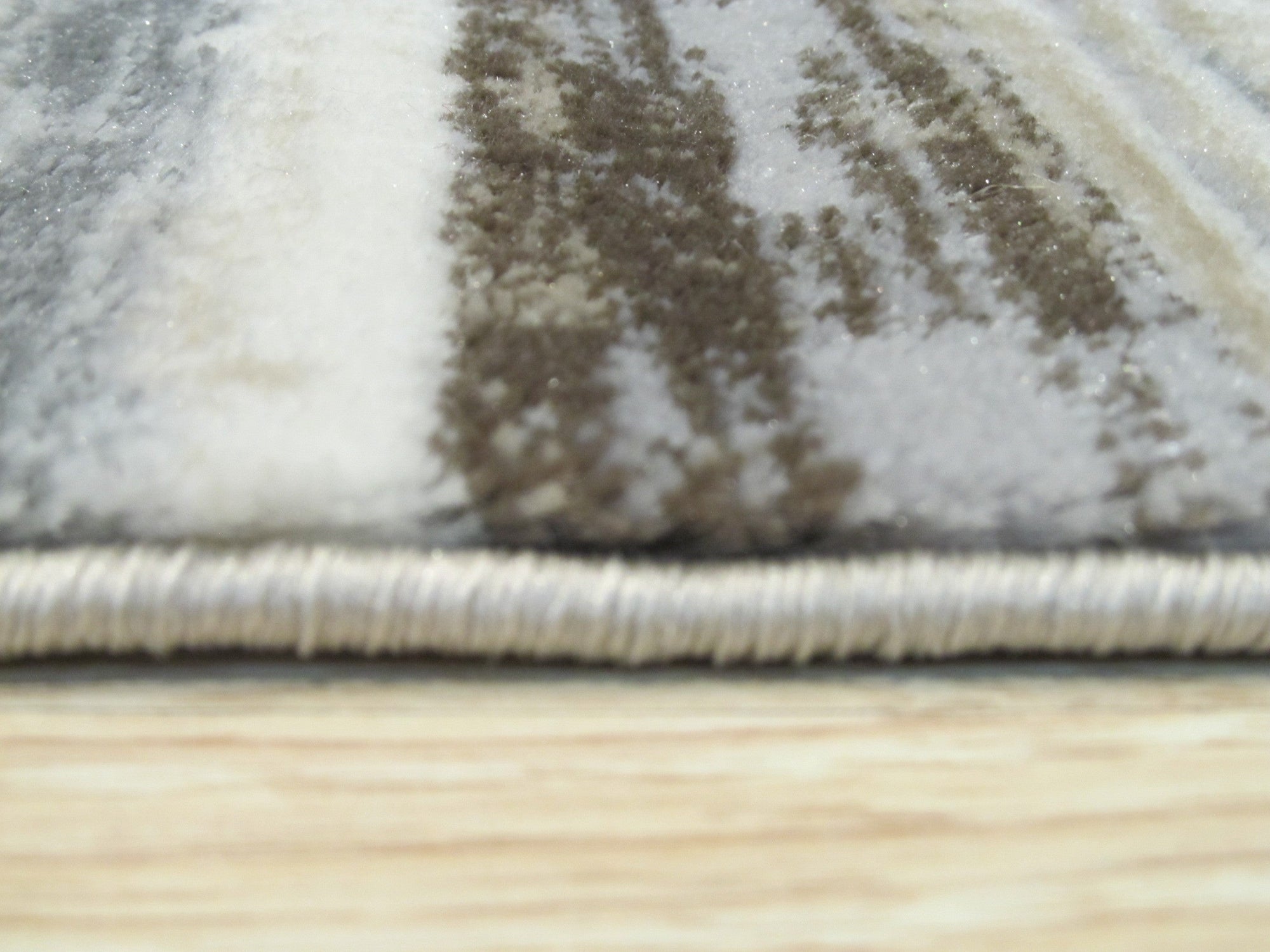 Enchanting Cassandra Ivory Machine-Made Rug, a textured ivory rug with a subtle, distressed pattern, anchors a bright living space with light wood floors and a neutral sofa.