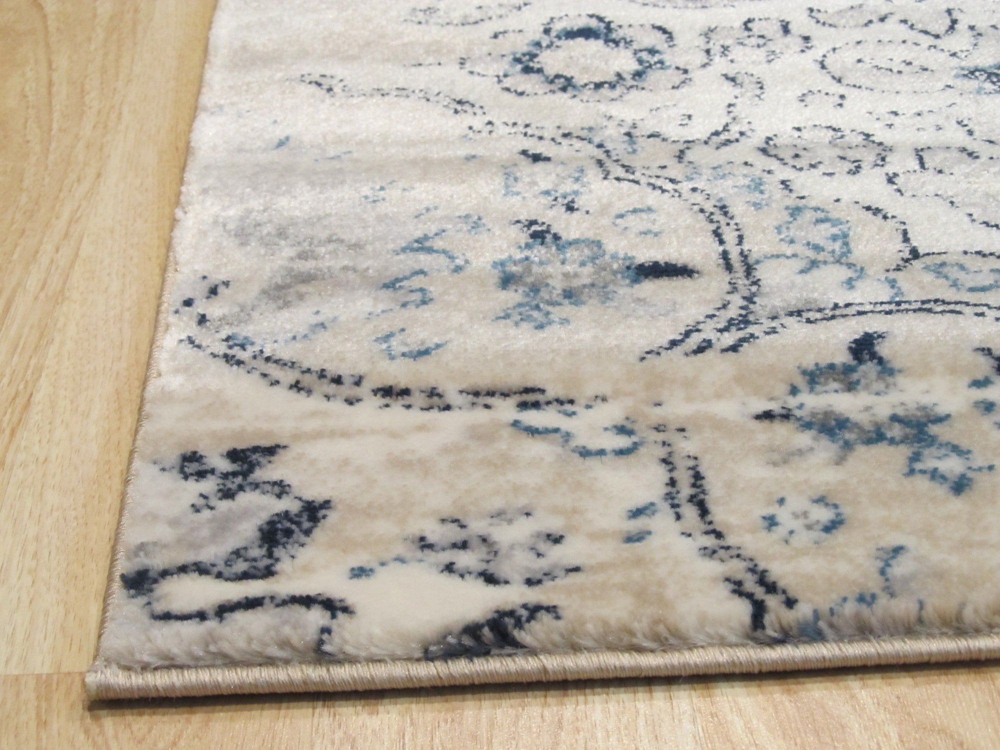 Iris Mira Ivory Machine Made Rug displayed in a bright living room setting, its intricate pattern adding warmth to the neutral decor.