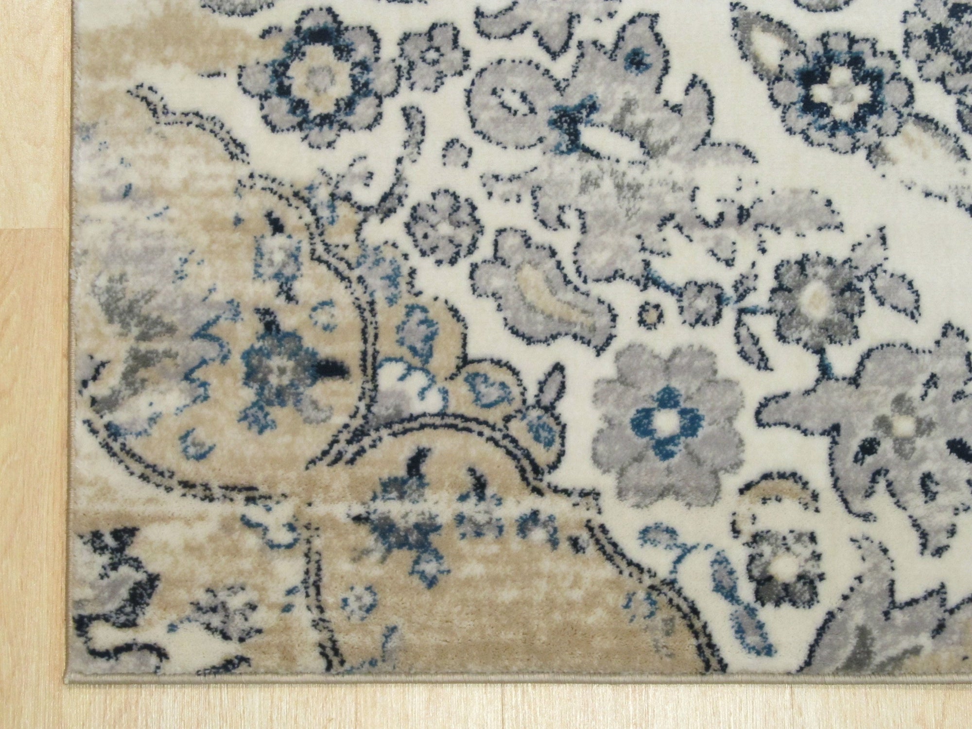 Iris Mira Ivory Machine Made Rug, its soft ivory tones and subtle floral-inspired design blending seamlessly into a bright living room; a glimpse of woven texture adds depth and warmth to the space.