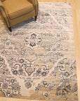 Iris Mira Ivory Machine Made Rug displayed in a bright, contemporary living space. Soft ivory tones and subtle textures of this machine-made rug complement the modern furniture and create a welcoming atmosphere.