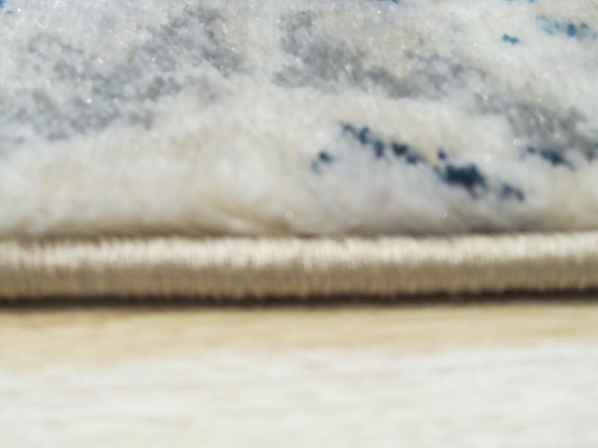 Iris Mira Ivory Machine Made Rug, showcasing its ivory hues and intricate floral pattern laid on a light hardwood floor, adding warmth and elegance to a bright, airy living space.
