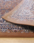 Iris Opulent Rust Machine Made Rug, seen in a living room setting, featuring a vibrant rust-colored palette and a swirling, opulent design.