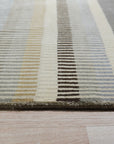 Zinnia Striped Green Handmade Wool Rug displayed in a bright, modern living room. Green and cream stripes create a cheerful, inviting atmosphere. Woven wool texture visible, showcasing the rug's handmade construction.