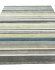 Zinnia Striped Green Handmade Wool Rug, vibrant green and cream stripes alternating across a handwoven wool texture, evokes a fresh, contemporary feel in a bright, sunlit room.
