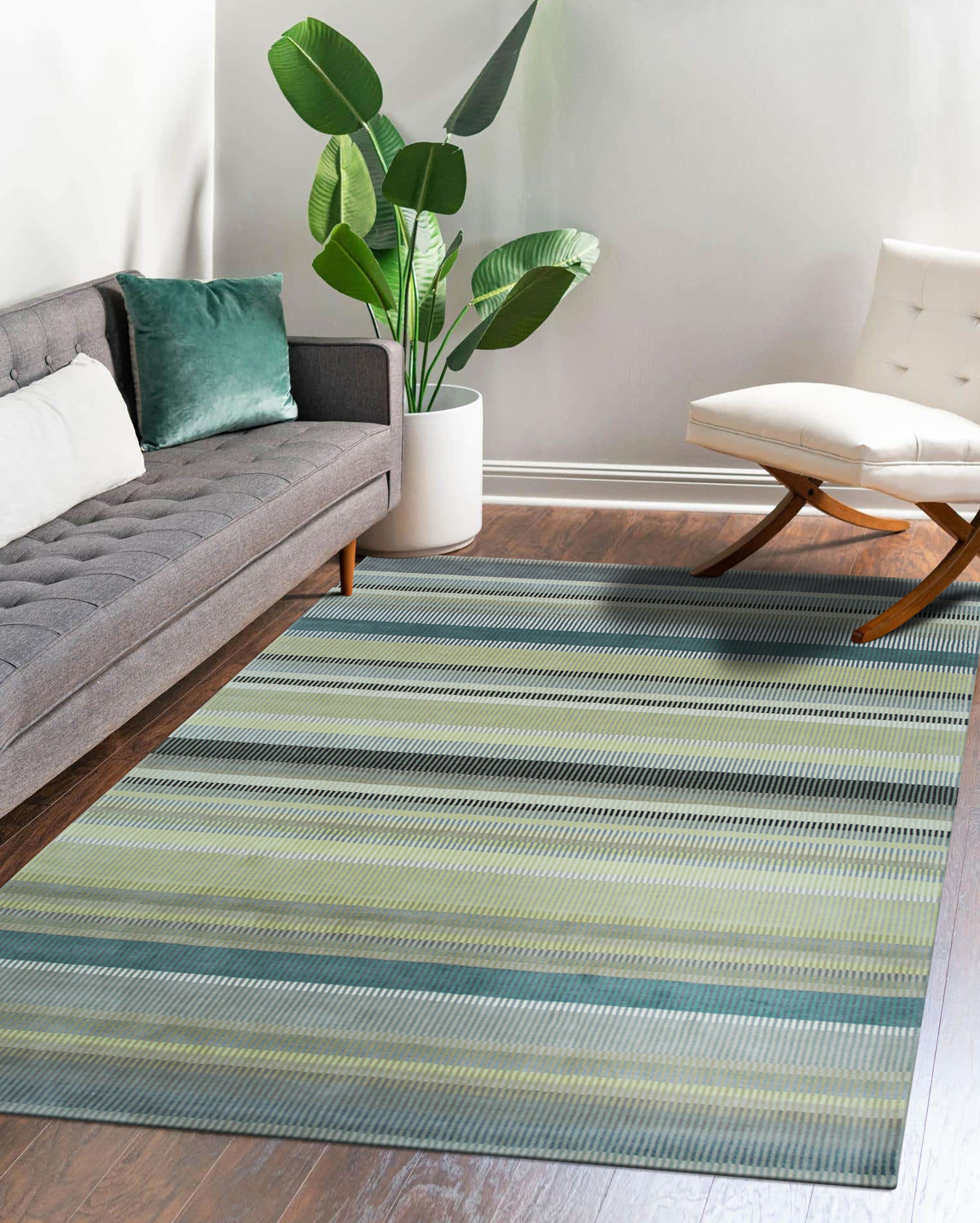 Zinnia Striped Green Handmade Wool Rug graces a living room, its vibrant green stripes energizing the space. Handcrafted wool offers soft texture and durable warmth beneath a modern coffee table.