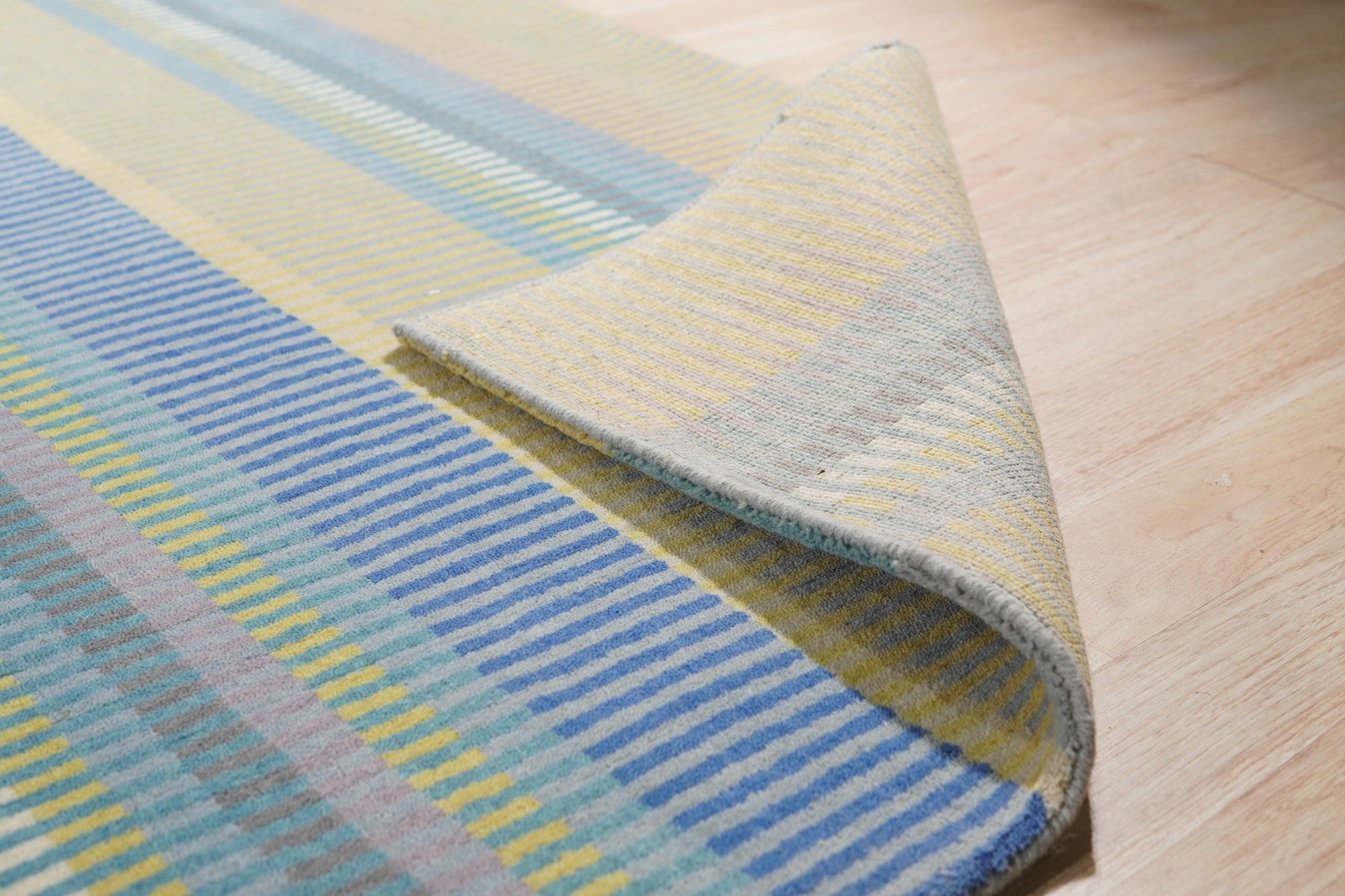 Serene Xena Green Handmade Wool Rug, its verdant hues and textured wool construction adding a calming touch to a warmly lit living space.