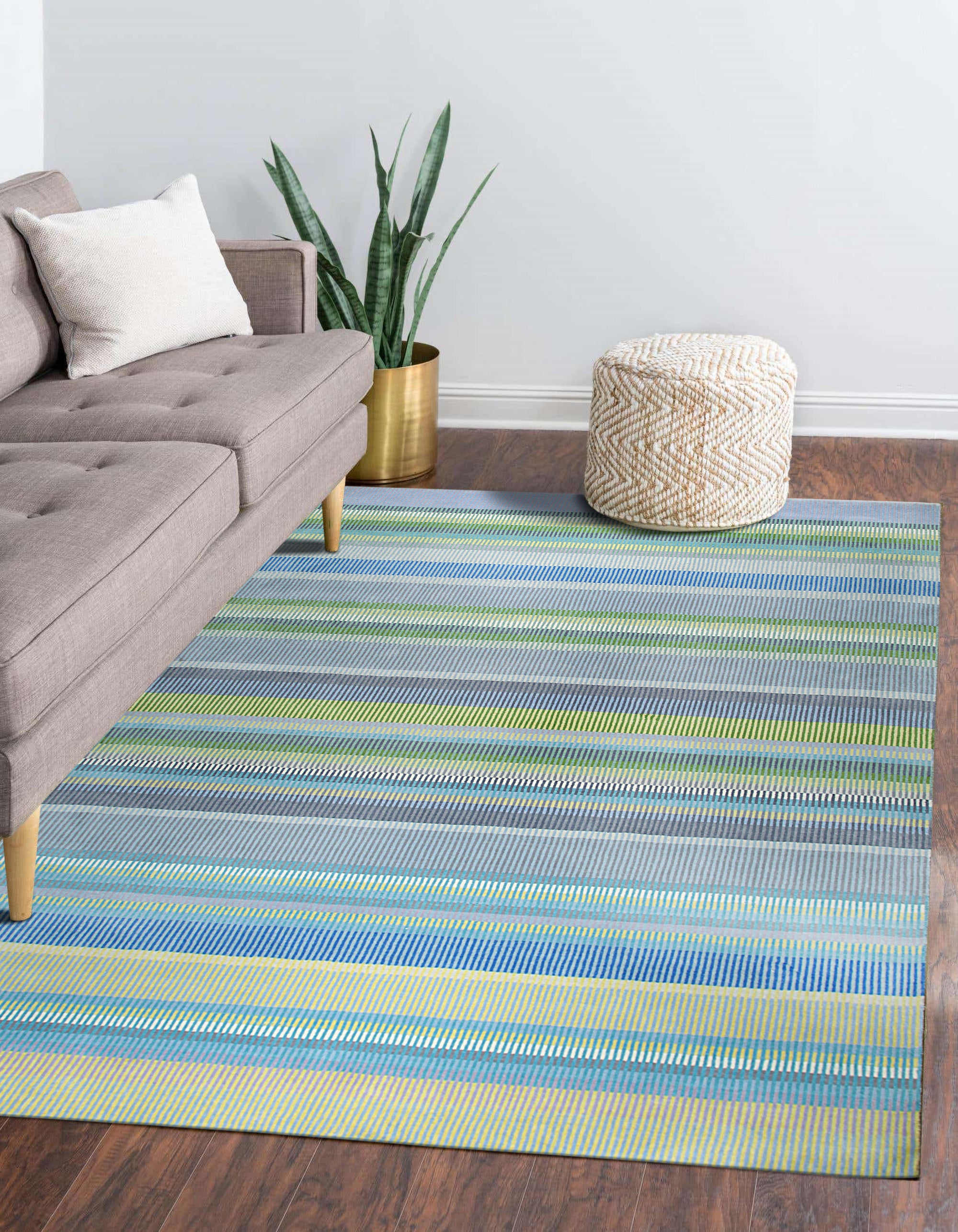 Serene Xena Green Handmade Wool Rug, a lush green wool rug with a subtle geometric pattern, displayed on a polished hardwood floor with natural light highlighting its texture.