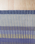 Comfortable Striped Lavender Handmade Wool Rug, soft lavender and neutral stripes create a serene and inviting texture, showcasing the handmade wool rug's cozy warmth and subtle pattern.