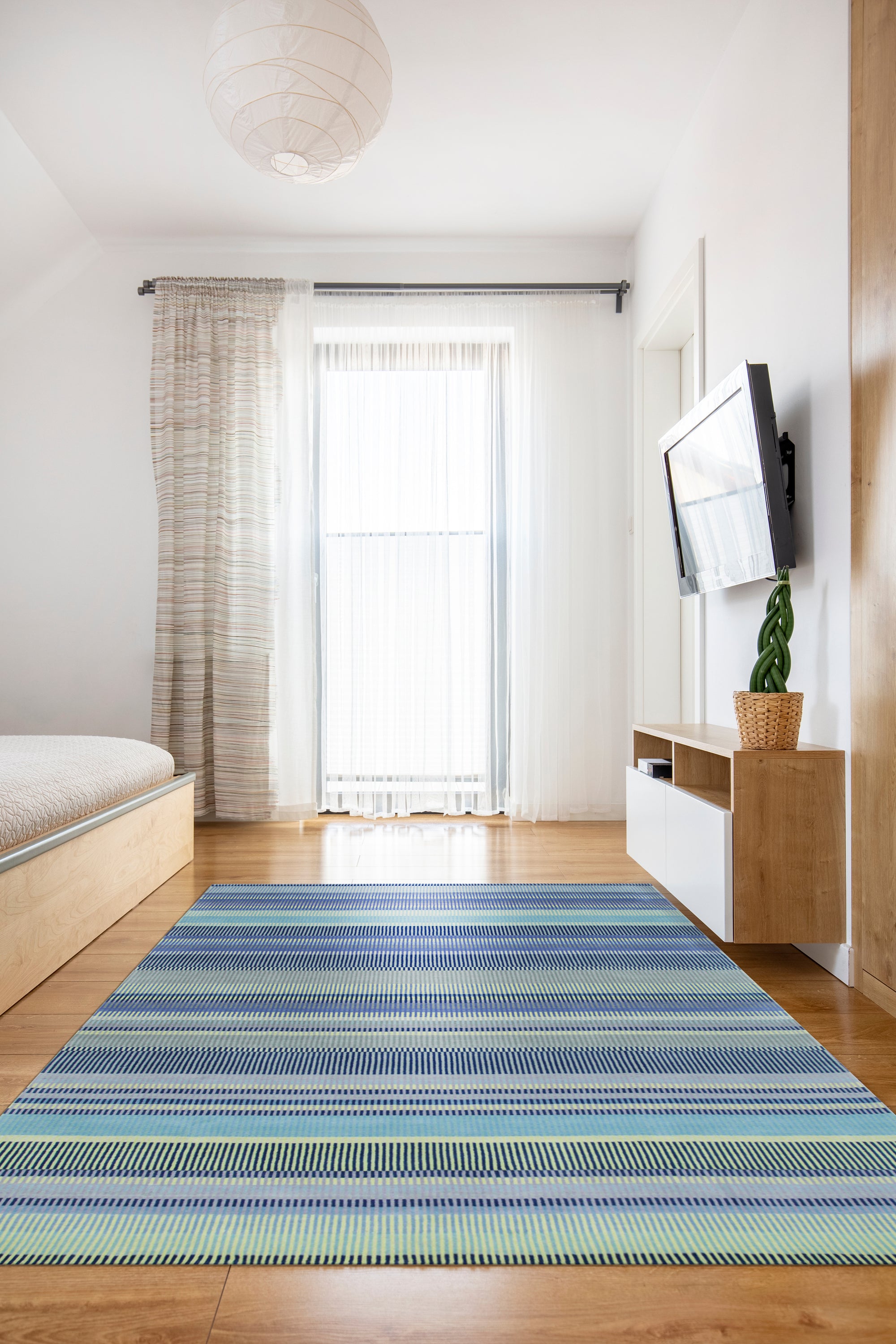 Comfortable Striped Lavender Handmade Wool Rug, soft bands of lavender, cream, and beige wool create a soothing striped pattern, subtly textured and lying elegantly on a light wood floor, bathed in natural light.