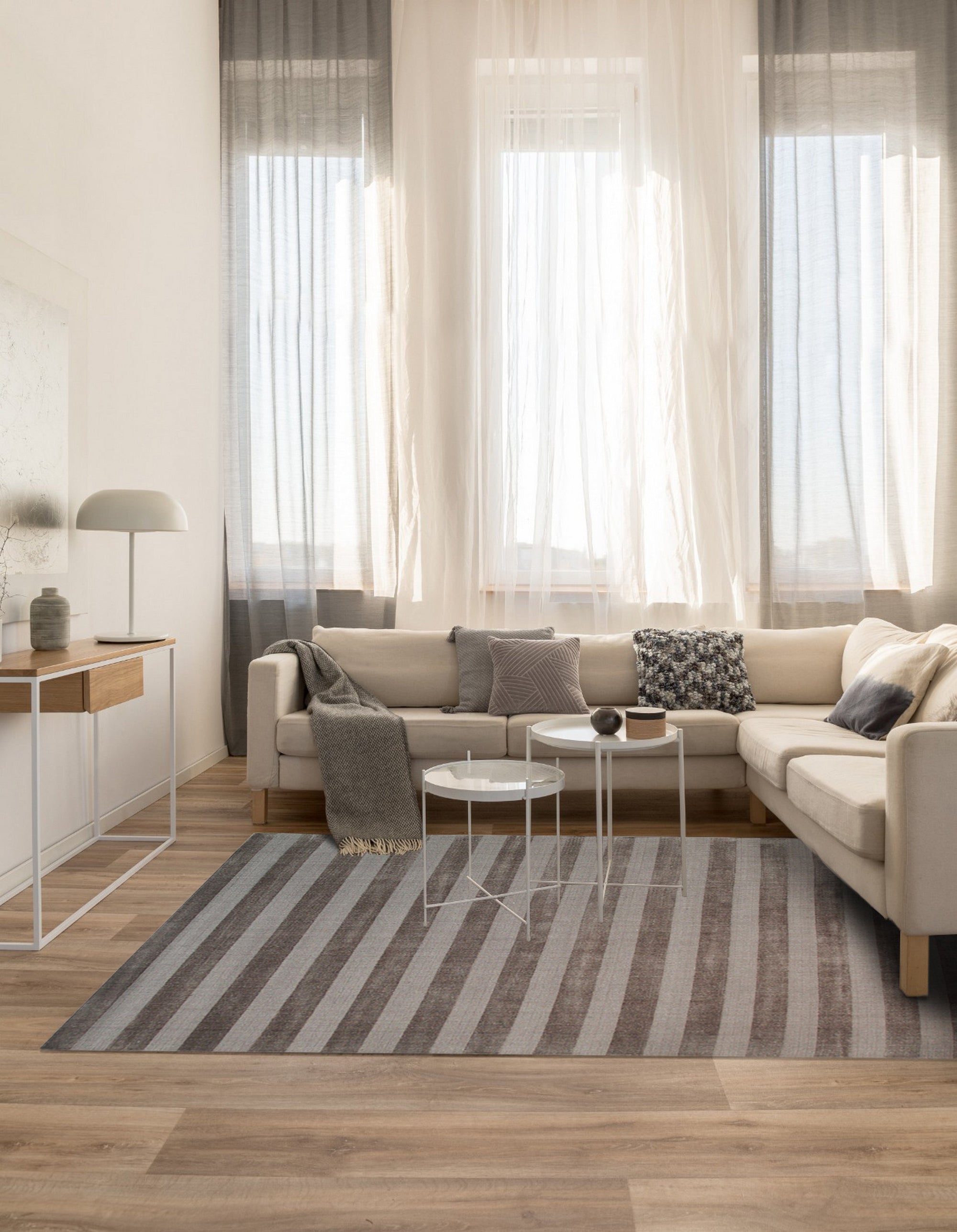 Yara Alluring Brown Handmade Wool Rug graces a warmly lit living room. Brown and cream tones swirl in a captivating design across this hand-made wool rug, anchoring a seating area with modern furniture.