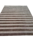 Yara Alluring Brown Handmade Wool Rug, warm brown tones and intricate patterns lending sophisticated texture to a living room setting.