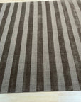 Yara Alluring Brown Handmade Wool Rug, featuring warm brown tones and a subtle, textured design, laying elegantly on a hardwood floor with natural light highlighting its wool construction.