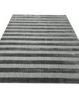 Yara Alluring Gray Handmade Wool Rug, showcasing its subtle gray tones and textured wool construction, adding a sophisticated touch to a bright, airy living space.