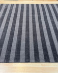 Yara Alluring Gray Handmade Wool Rug, displaying subtle variations in gray tones and textures, grounding a bright living room with modern furniture.