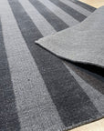 Yara Alluring Gray Handmade Wool Rug, showcasing its subtle variations in gray wool, textured weave, and plush feel, complementing a modern living room with minimalist decor and a warm, inviting ambiance.