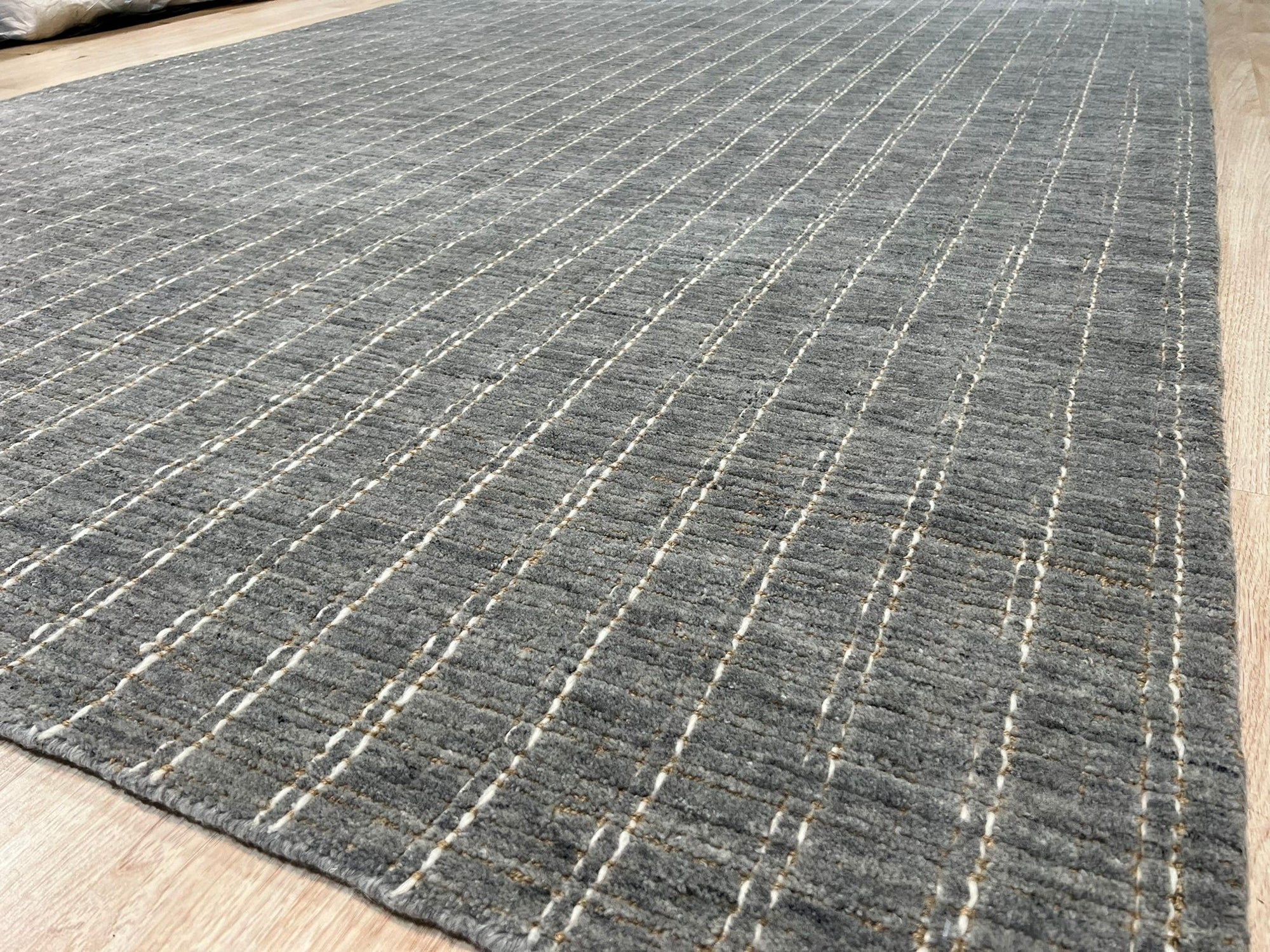 Delicate Giselle Gray Handmade Wool Rug, displaying subtle, interwoven patterns in muted grays and creams, filling the frame with its soft texture and detailed craftsmanship.