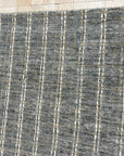 Delicate Giselle Gray Handmade Wool Rug, a soft gray handmade wool rug with subtle tonal variations and a plush texture, seen in a bright, minimalist living room setting.