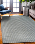 Delicate Giselle Gray Handmade Wool Rug displayed on a light hardwood floor, its subtle pattern of varying gray tones creating a calming, textured surface in a modern living space.