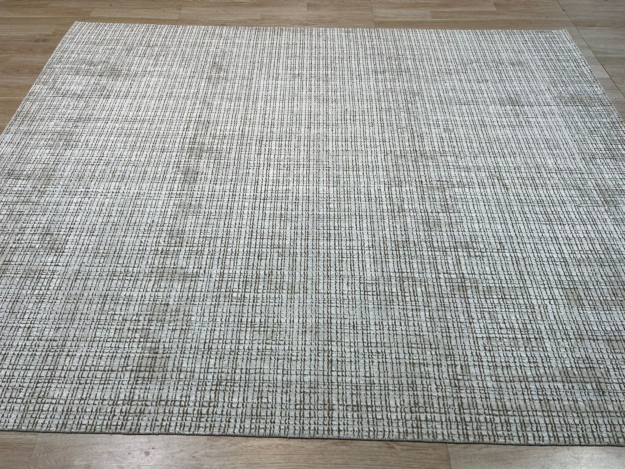 Warm Sarrah White Handmade Bamboo Silk Rug in a bright, modern living room, its soft, white texture adding luxurious warmth.