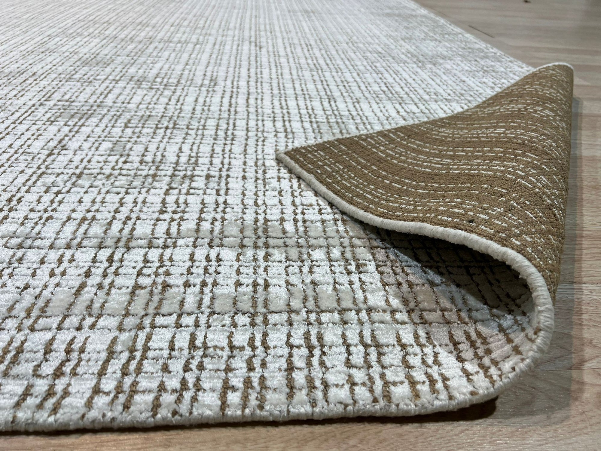 Warm Sarrah White Handmade Bamboo Silk Rug, a luminous ivory rug featuring subtle texture and shimmering bamboo silk, softly illuminates a modern living space.