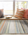 Louie Ophelia Beige Handmade Wool Rug graces a softly lit room, its intricate pattern adding subtle texture to the neutral décor. Warm beige tones and the rug's hand-knotted wool construction offer a luxurious feel underfoot.