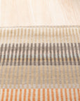 Louie Ophelia Beige Handmade Wool Rug, displaying intricate patterns and textures in soft beige tones, covers the floor in a well-lit living space.