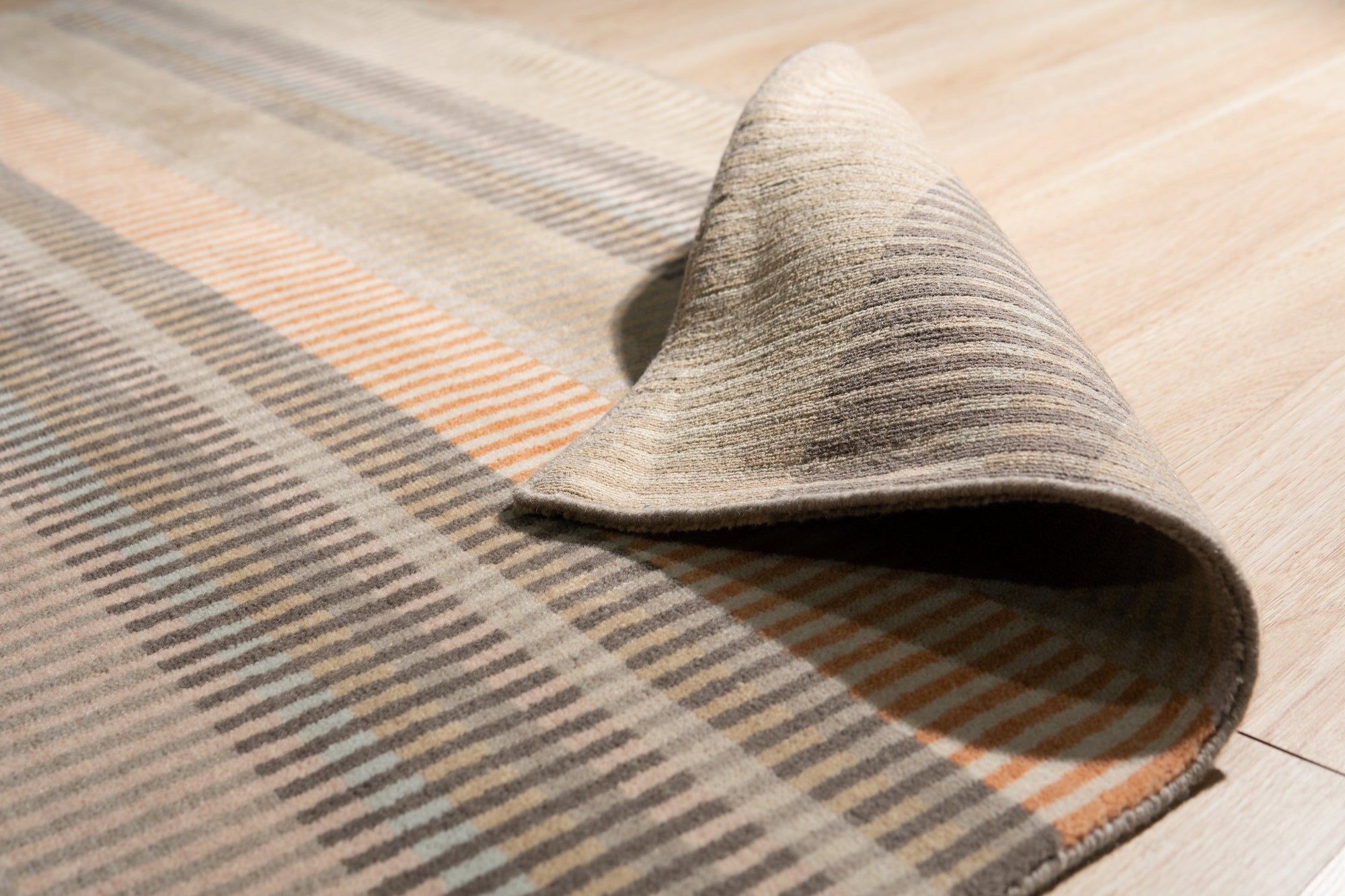Louie Ophelia Beige Handmade Wool Rug, soft beige wool layers texture and subtle depth in a modern living room, offering comfort and warmth underfoot.