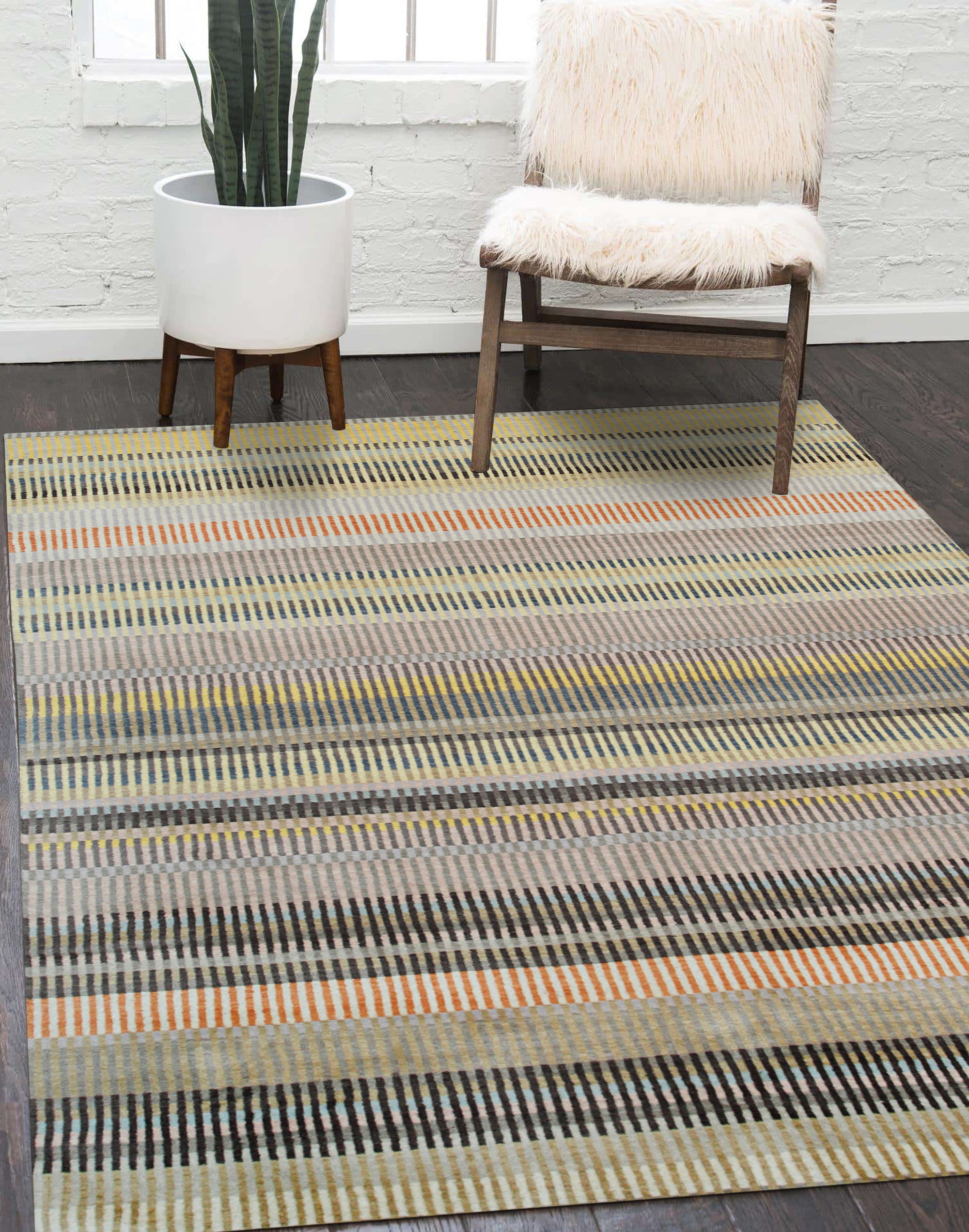 Louie Ophelia Beige Handmade Wool Rug, displaying intricate patterns and a soft beige hue, complements a modern living space with dark wood flooring and a minimalist aesthetic.