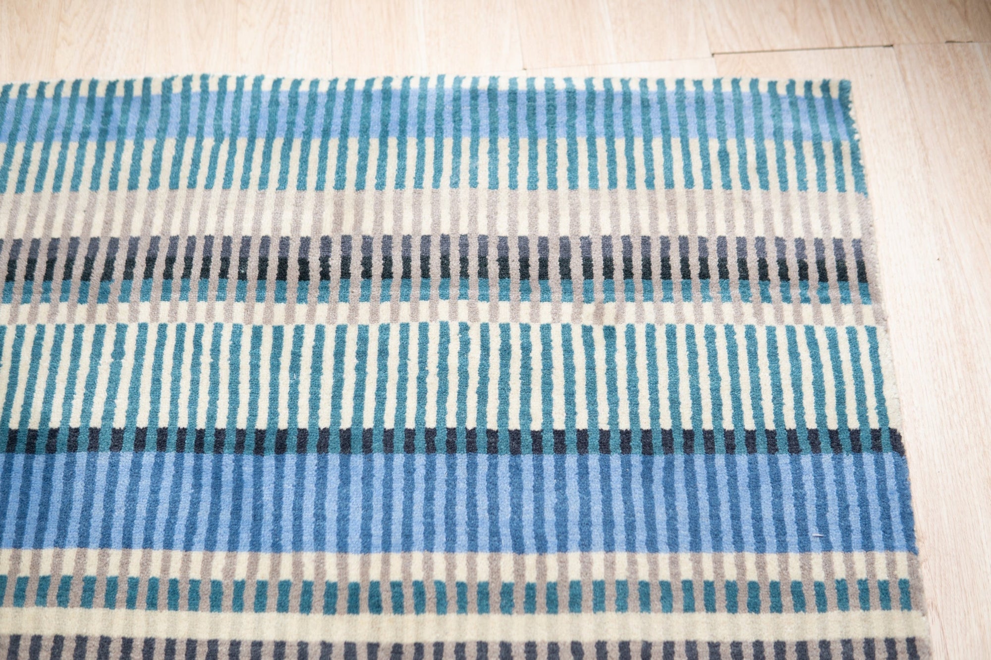 Louie Ophelia Ocean Blue Handmade Wool Rug, vibrant ocean blues swirling across hand-knotted wool, offering a glimpse of textured artistry and coastal serenity underfoot.