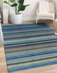 Louie Ophelia Ocean Blue Handmade Wool Rug, waves of deep ocean blue cascade across hand-knotted wool, creating a calming and textural floor covering in a warmly lit interior.
