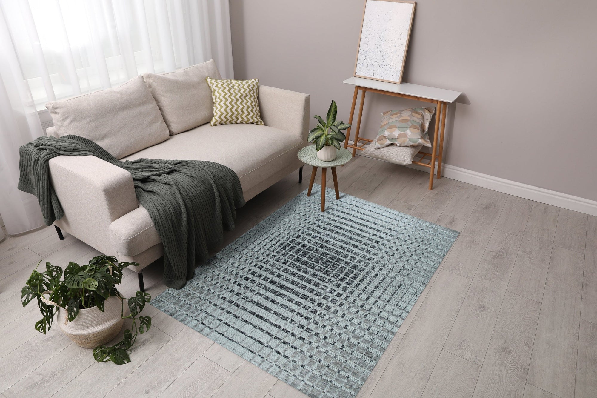 Nadia Ava Gray Handmade Wool Rug, showcasing its subtle gray tones and hand-woven wool texture in a living room setting with modern furniture.