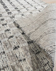 Nadia Ava Gray Handmade Wool Rug, featuring a subtle geometric pattern in varying shades of gray, displayed in a living room setting with modern furniture.