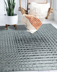 Nadia Ava Gray Handmade Wool Rug, blending soft grays in a subtle, textured design, complements a modern living room with neutral furnishings.