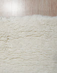 Willow Sarrah Ivory Handmade Wool Rug, an ivory wool rug with a subtle, intricate pattern, displayed in a brightly lit living room setting, suggesting warmth and comfort.
