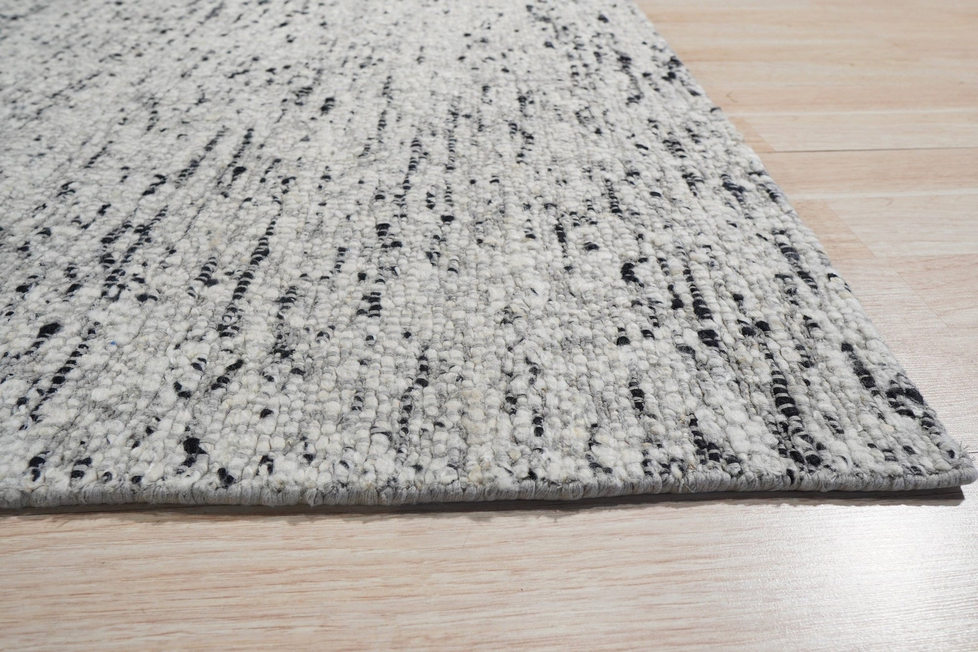 Opulent Alluring Dark Gray Handmade Wool Rug, its rich dark gray tones and dense wool weave providing luxurious texture and warmth to a contemporary living space with neutral furniture.