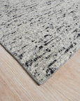 Opulent Alluring Dark Gray Handmade Wool Rug, a dark gray wool rug with subtle textural variations, lies softly on a hardwood floor, its rich color grounding the minimalist space.