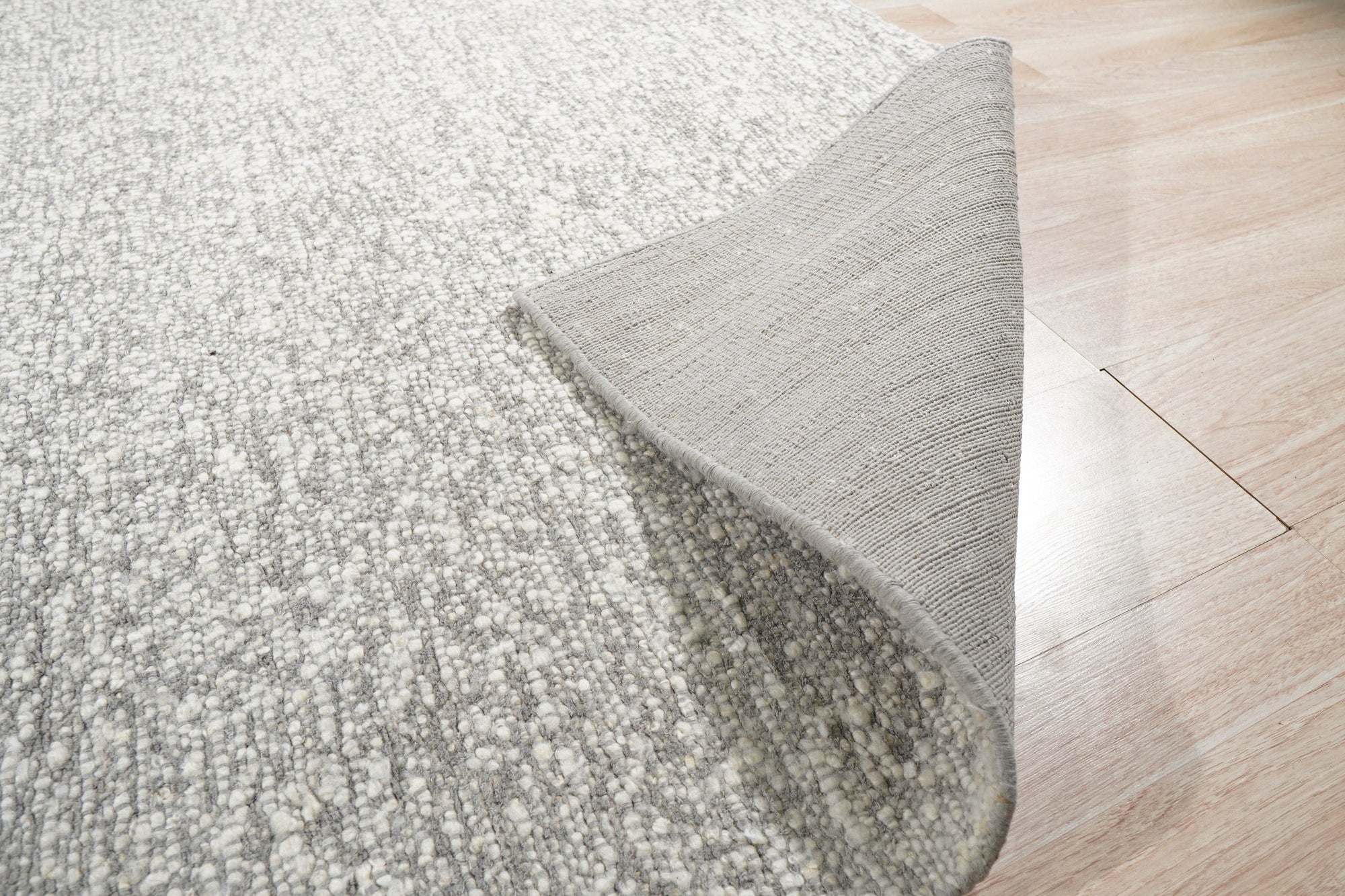 Opulent Alluring Silver Handmade Wool Rug, its shimmery silver tones and textured wool construction catching the light, adds subtle luxury to a bright, airy space.