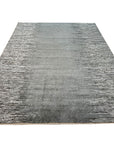 Tessa Maya Gray Hand Knotted Wool Rug, showcases its intricate pattern and texture in a stylishly decorated room, adding warmth and sophistication to the space.