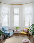 Freya Graceful Pink Handmade Wool Rug, a soft pink wool rug with subtle, abstract patterns, nestled in a cozy living room setting with a white sofa and natural light.