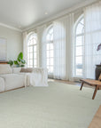 Bespoke Delicate Ivory Handmade Wool Rug displayed in a bright, minimalist living space, its soft ivory tones complementing the light hardwood flooring. The rug's subtle texture and handmade construction add warmth and sophistication to the room.