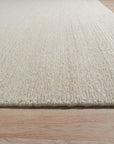 Bespoke Delicate Ivory Handmade Wool Rug, softly textured and ivory-toned, lies flat on a light surface. Subtle variations in the wool weave hint at its handcrafted construction, creating a warm and inviting feel.