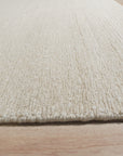Bespoke Delicate Ivory Handmade Wool Rug, its creamy texture and subtle pattern softening a room bathed in warm, natural light. Hand-knotted wool construction evident in the luxurious pile, its ivory hue bringing serene elegance to the space.