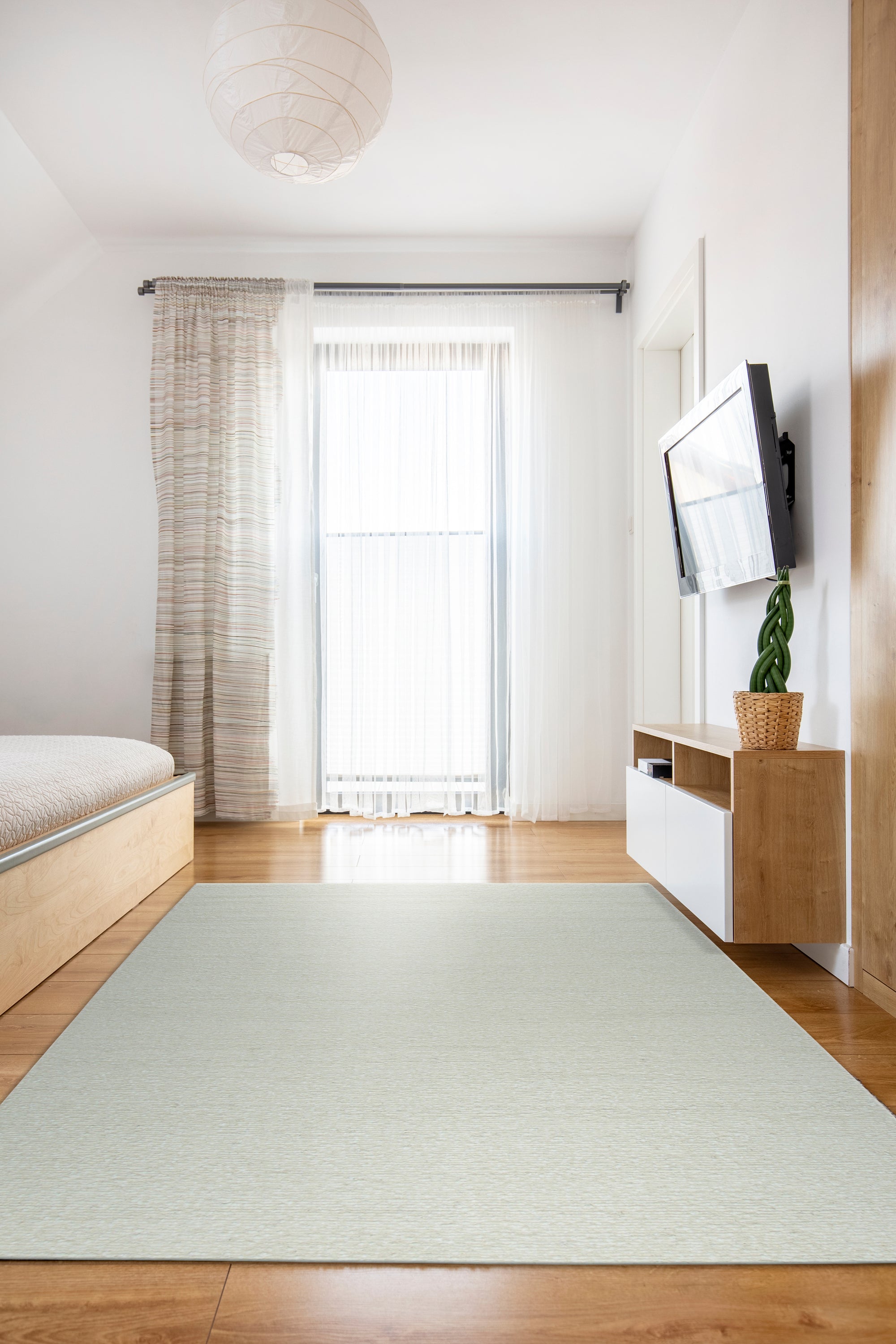 Bespoke Delicate Ivory Handmade Wool Rug, its plush ivory wool pile inviting touch and showcasing subtle texture variations across its handmade construction, displayed in a warmly lit, minimalist room.