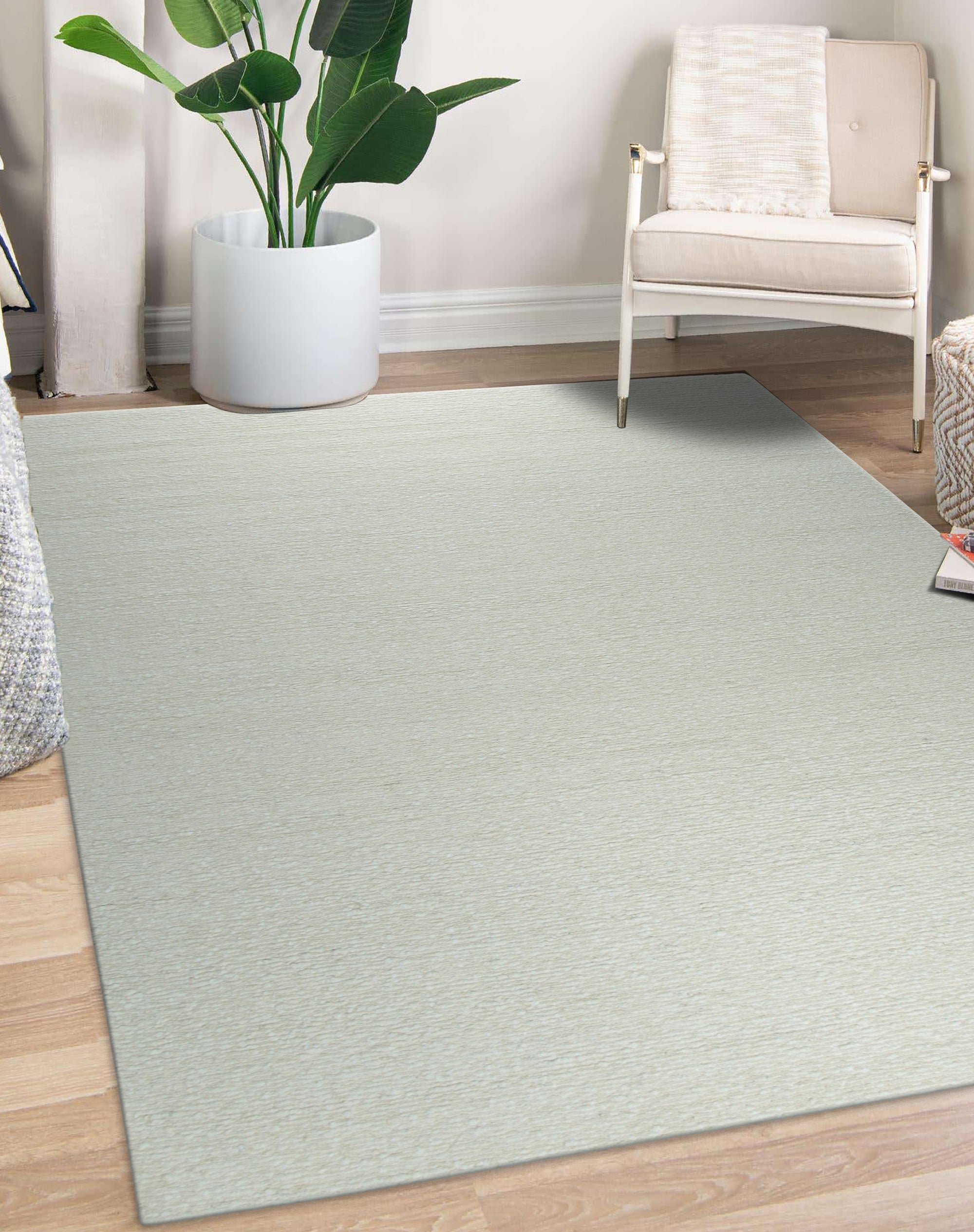 Bespoke Delicate Ivory Handmade Wool Rug, showcasing its texture and subtle variations in ivory tones, laid against a light surface, its handcrafted wool construction evident in the pile's soft appearance.